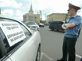 Милиционер у машины. Фото: с сайта kommersant.ru