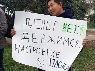 Активист с плакатом "Денег нет. Держимся. Настроение плохое". Фото: Аригус Активист с плакатом "Денег нет. Держимся. Настроение плохое". Фото: Аригус