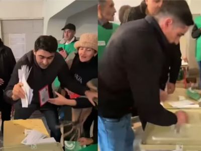 Кадр из видео, на котором мужчины заталкивают множество бюллетеней в избирательную урну Кадр из видео, на котором мужчины заталкивают множество бюллетеней в избирательную урну